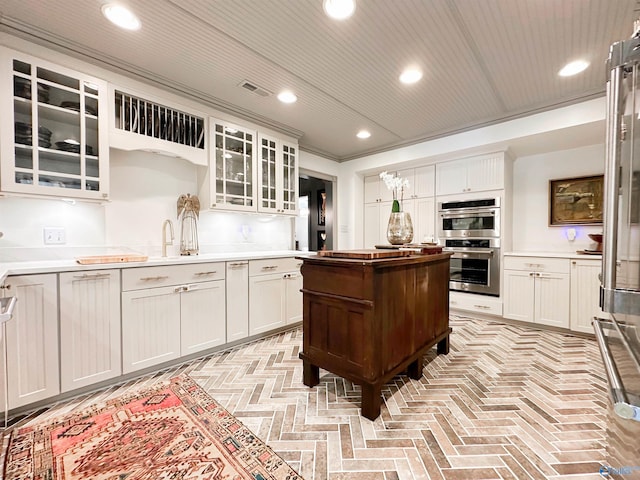 kitchen featuring double oven, recessed lighting, white cabinetry, and light countertops