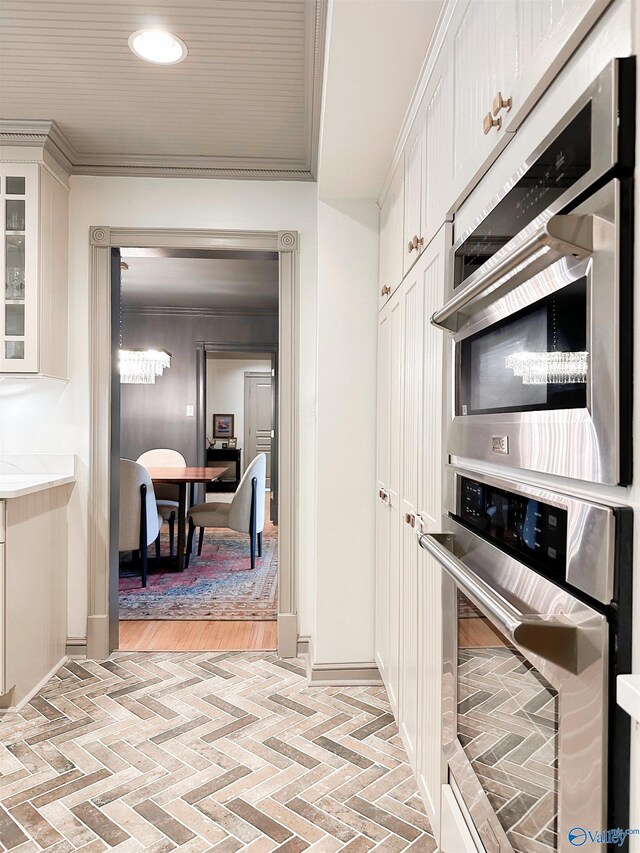 kitchen featuring crown molding, brick floor, glass insert cabinets, white cabinets, and recessed lighting