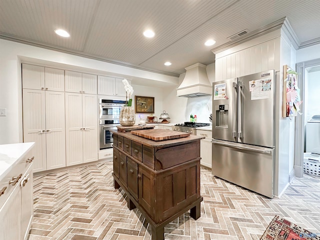 kitchen featuring premium range hood, brick floor, visible vents, and stainless steel appliances