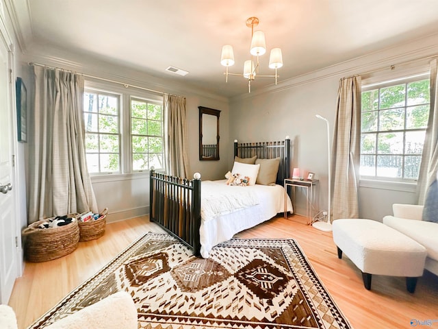 bedroom with crown molding, multiple windows, visible vents, and light wood-style flooring