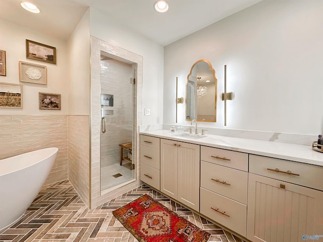 bathroom with a shower stall, brick floor, vanity, a freestanding bath, and recessed lighting