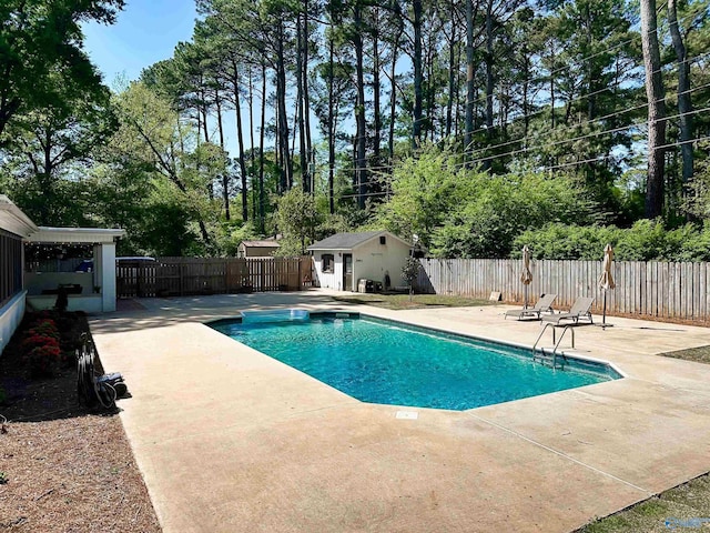 view of pool with a fenced backyard, an outbuilding, a patio, and a fenced in pool