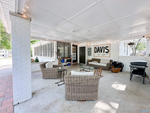 view of patio featuring grilling area, outdoor lounge area, electric panel, and a sunroom