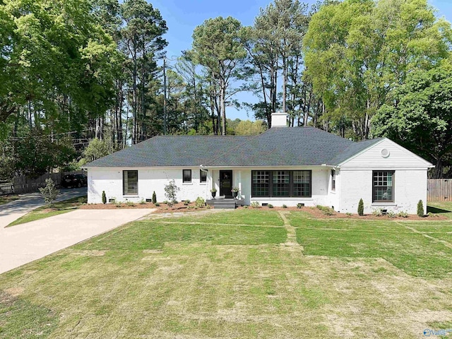 ranch-style house with fence, a chimney, and a front yard