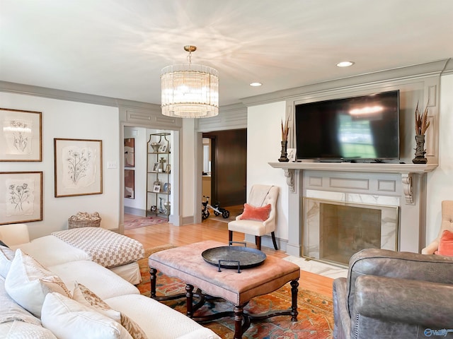 living room with a fireplace, wood finished floors, an inviting chandelier, and recessed lighting
