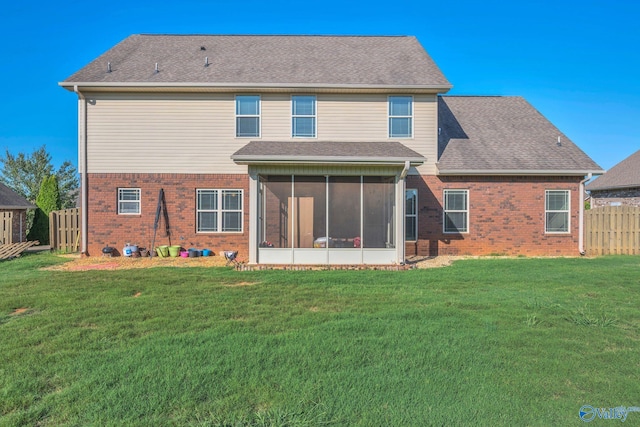 rear view of property featuring a sunroom and a lawn