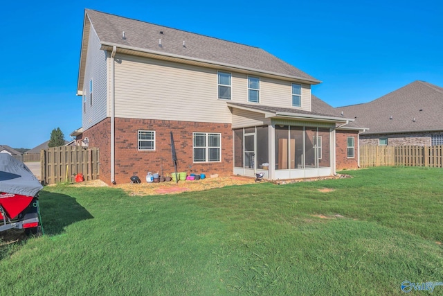 rear view of house featuring a sunroom and a yard