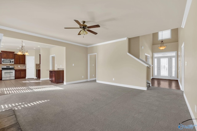 unfurnished living room with ceiling fan with notable chandelier, crown molding, and light colored carpet