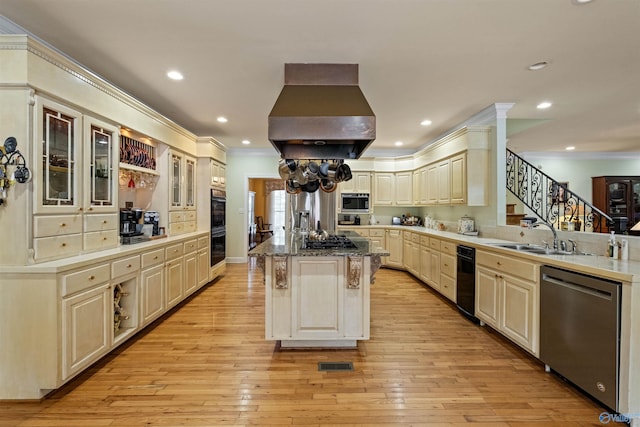 kitchen featuring a kitchen bar, a kitchen island, island exhaust hood, stainless steel appliances, and cream cabinets