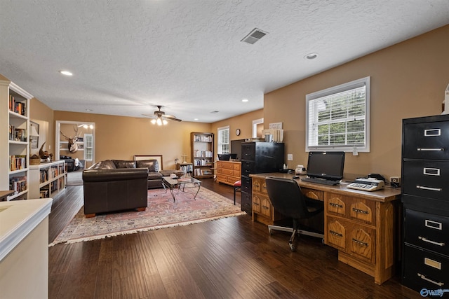 office area with ceiling fan, dark wood-type flooring, and a textured ceiling