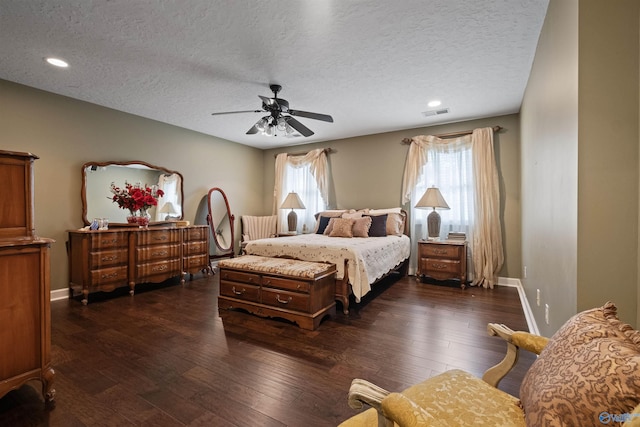 bedroom featuring dark hardwood / wood-style flooring, a textured ceiling, and ceiling fan