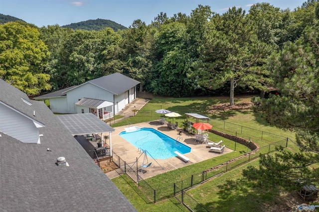 view of swimming pool with a patio, a diving board, and a lawn