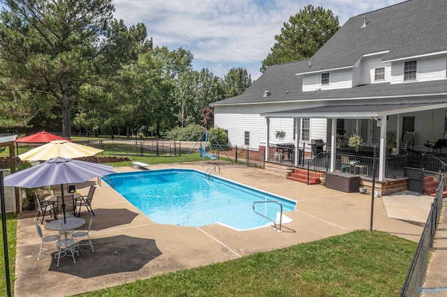 view of pool with a patio and a diving board