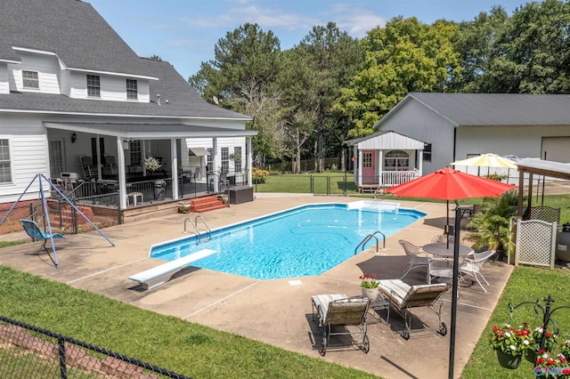 view of swimming pool featuring a patio and a diving board