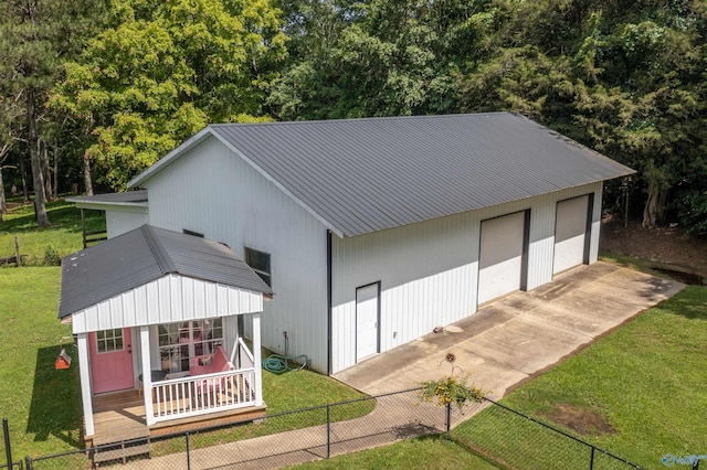 exterior space with a porch, a garage, and a lawn