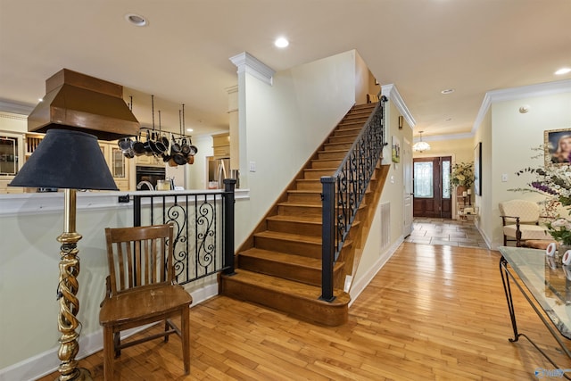 stairs featuring wood-type flooring and ornamental molding