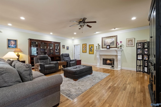 living room with ornamental molding, ceiling fan, and light wood-type flooring