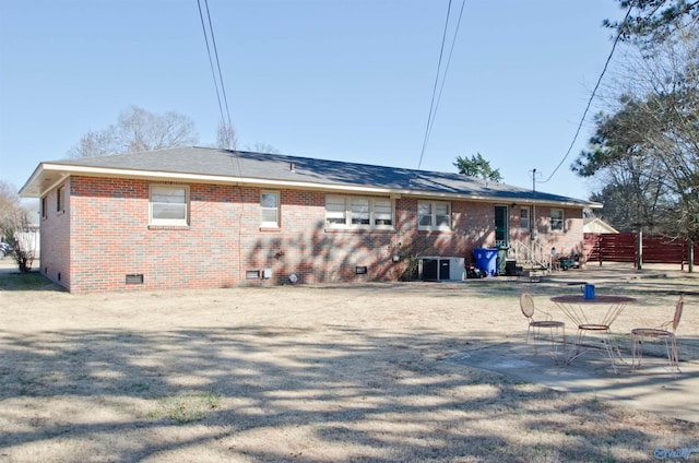 back of house with crawl space, a shingled roof, and brick siding