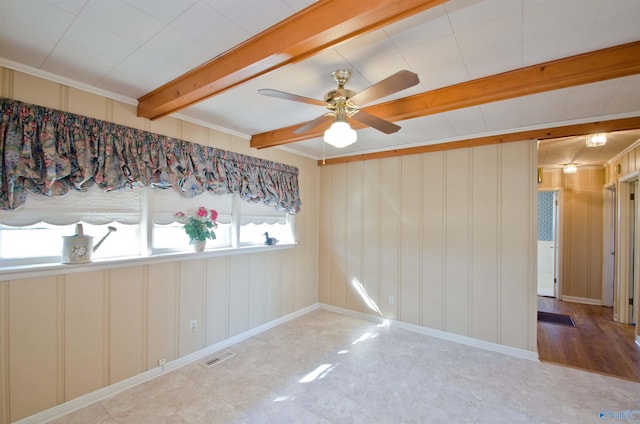 spare room with baseboards, ceiling fan, visible vents, and beamed ceiling