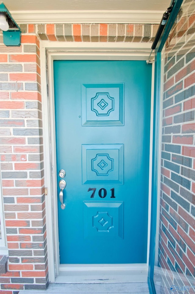 entrance to property featuring brick siding