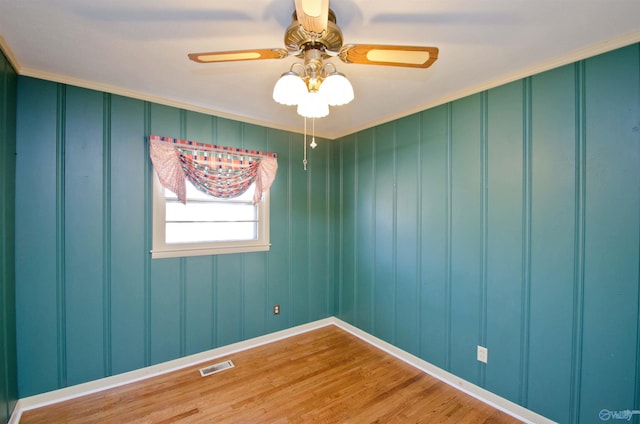 empty room with visible vents, ceiling fan, and wood finished floors