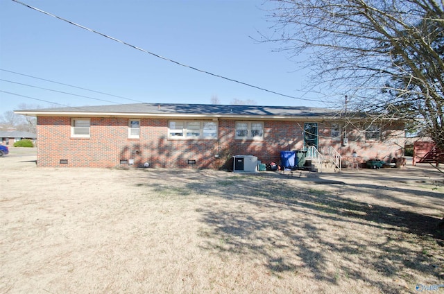 back of property featuring brick siding and crawl space