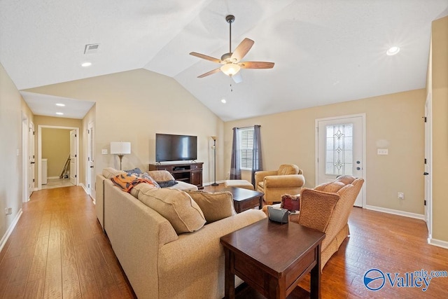 living room featuring visible vents, hardwood / wood-style floors, vaulted ceiling, ceiling fan, and baseboards