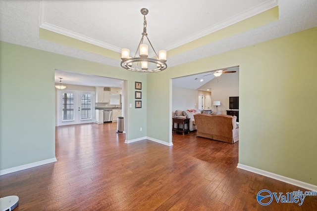 dining space featuring a raised ceiling, crown molding, wood-type flooring, and baseboards