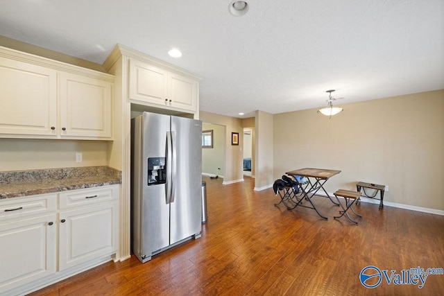 kitchen featuring dark wood-style floors, stone counters, recessed lighting, stainless steel fridge, and baseboards