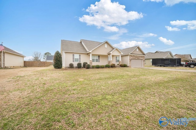 view of front of home featuring an attached garage, fence, and a front yard