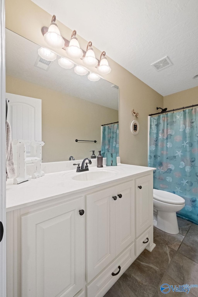 bathroom with toilet, visible vents, a textured ceiling, and vanity