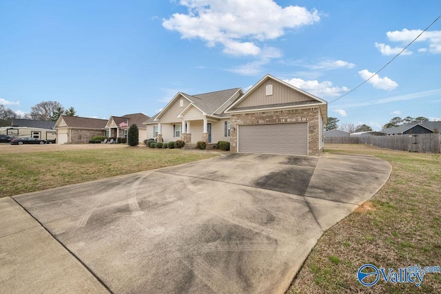 view of front of house featuring a garage, concrete driveway, fence, a front lawn, and brick siding