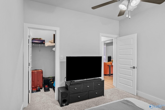 carpeted bedroom featuring a spacious closet, a closet, and ceiling fan