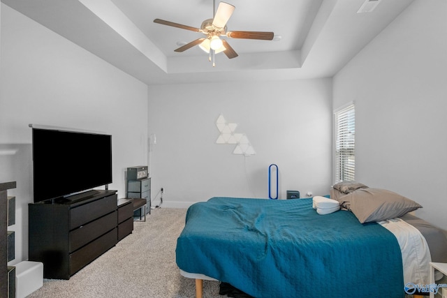 bedroom featuring a raised ceiling, carpet floors, and ceiling fan