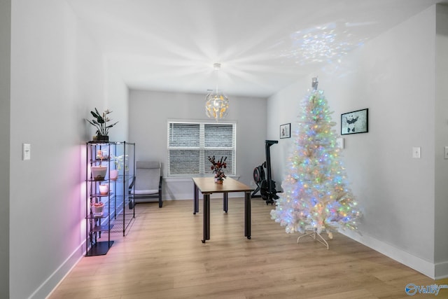 miscellaneous room featuring an inviting chandelier and light hardwood / wood-style flooring