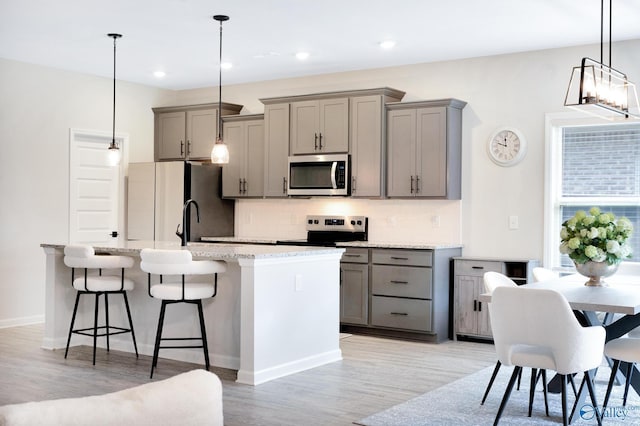 103 Barlow Way, Owens Cross Roads, AL 35763 - kitchen with appliances with stainless steel finishes, gray cabinets, a kitchen island with sink, tasteful backsplash, and recessed lighting