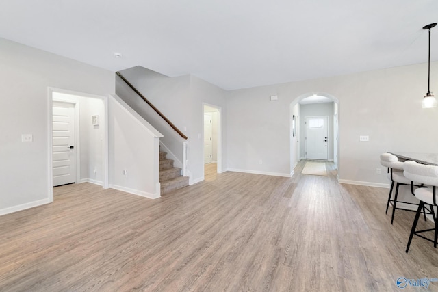 103 Barlow Way, Owens Cross Roads, AL 35763 - unfurnished living room with light wood finished floors, stairs, and arched walkways