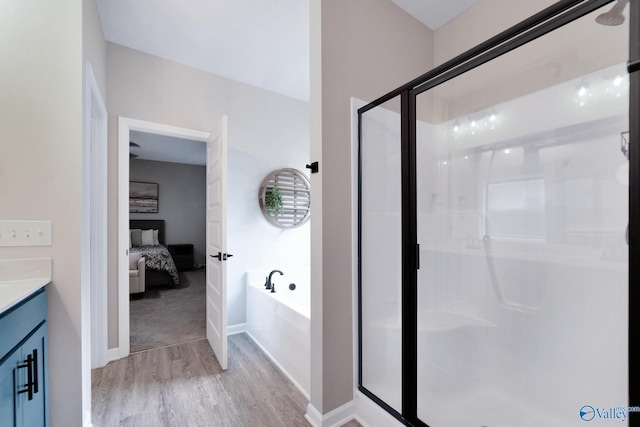 103 Barlow Way, Owens Cross Roads, AL 35763 - ensuite bathroom with wood finished floors, a stall shower, vanity, and a bath