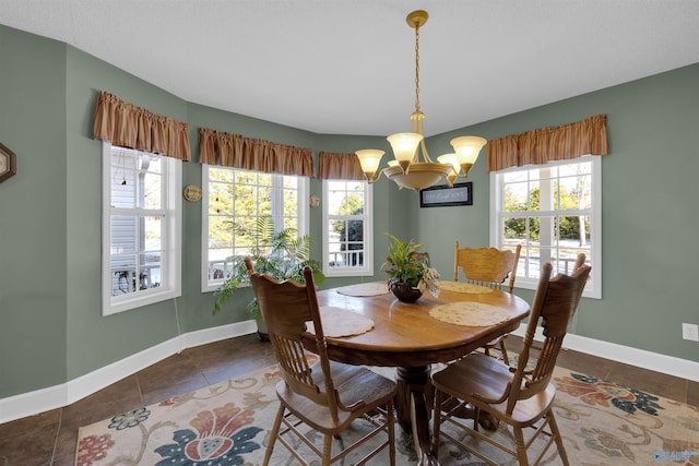 dining area featuring a notable chandelier and dark tile patterned flooring