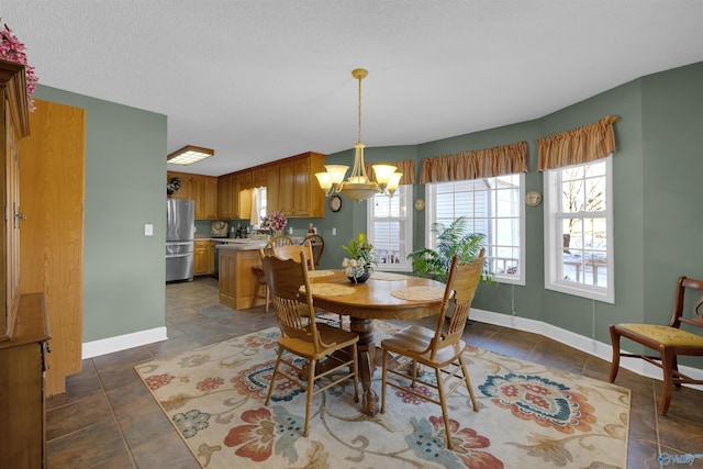 dining space featuring dark tile patterned floors and a notable chandelier