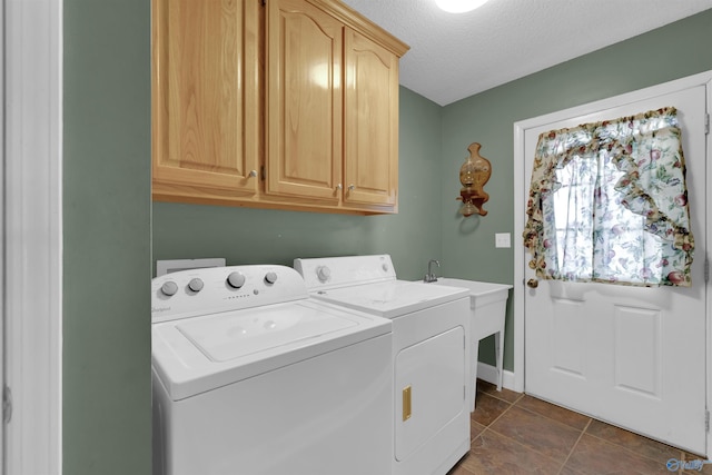 clothes washing area featuring cabinets, a textured ceiling, dark tile patterned floors, and independent washer and dryer