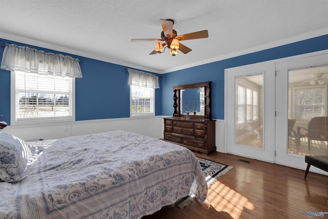 bedroom with ceiling fan, wood-type flooring, crown molding, and a textured ceiling