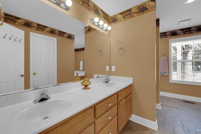 bathroom with a textured ceiling, tile patterned floors, and vanity