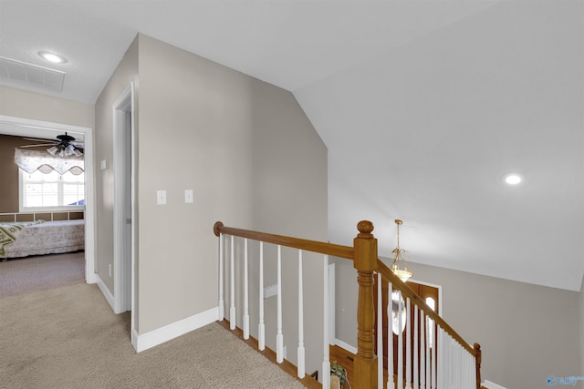 corridor with lofted ceiling and light colored carpet