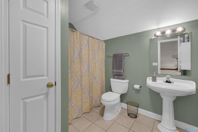 bathroom featuring lofted ceiling, tile patterned flooring, and toilet