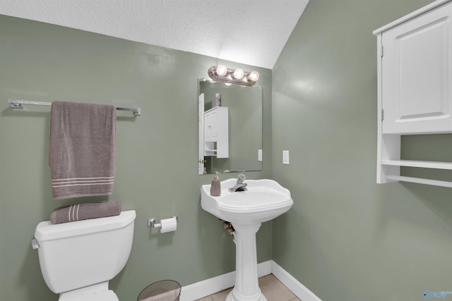 bathroom featuring a textured ceiling, toilet, and tile patterned flooring