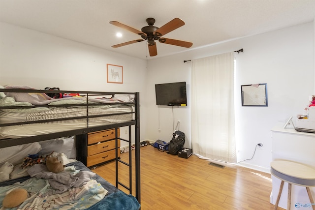 bedroom featuring visible vents, light wood-style floors, and a ceiling fan