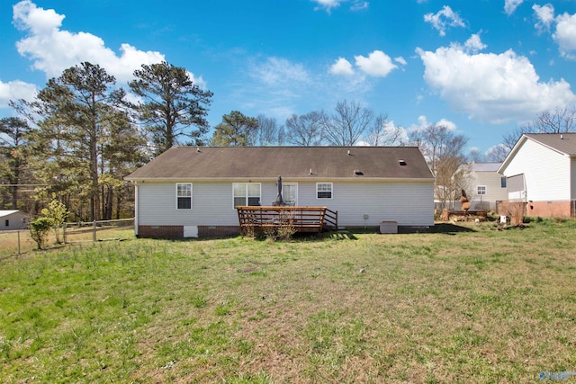 rear view of property with a yard, a deck, and fence