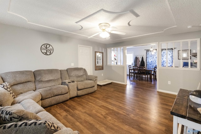 living room with dark wood finished floors, baseboards, a textured ceiling, and ceiling fan