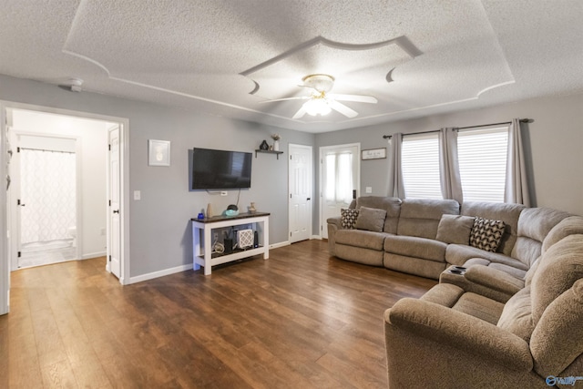living room with dark wood-style floors, a textured ceiling, baseboards, and ceiling fan